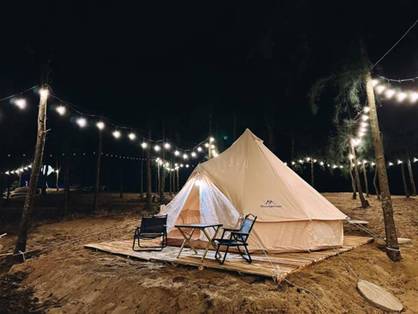 A tent and chairs in a field at night

Description automatically generated